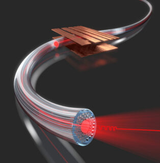 Im Flug gemessen: Mit einem Mikrokügelchen, das durch den hohlen Kanal im Inneren einer photonischen Kristallfaser fliegt, messen Forscher des Max-Planck-Instituts für die Physik des Lichts verschiedene physikalische Größen, zum Beispiel das elektrische Feld entlang der optischen Faser. Die Ortsauflösung ist dabei so hoch, dass die Forscher die Anordnung und Größe von Elektroden, dargestellt als kupferfarbenen Platten ober- und unterhalb der Faser, selbst dann noch genau abbilden können, wenn diese nur 200 Mikrometer breit sind. (Bild: Luca Fiorentini)