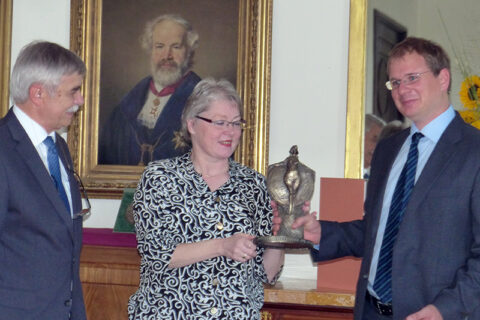 Dr. Feilhauer (rechts) empfängt die Statuette des Wissenschaftspreises von Dr. Mätzing (Mitte) und Prof. em. Dr. Popp (links) auf dem Kongress für Geographie 2017 in Tübingen (Foto: Georg Glasze)