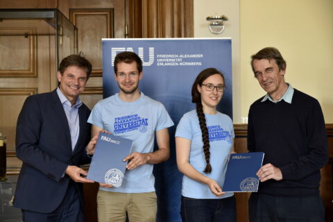 Die Studierenden Contanze Gerner und Felix Amler (m.) haben mit zusammen Kommilitonen die neue Photovoltaikanlage am Lehrstuhl für Laserphysik errichtet. Prof. Dr. Hundhausen (r.), Vorsitzender des Solarvereins Sonnenenergie Erlangen e.V., übergab die Anlage an den Präsidenten der FAU, Prof. Dr. Hornegger (l.), nun mit einem Vertrag. (Bild: FAU/Boris Mijat)