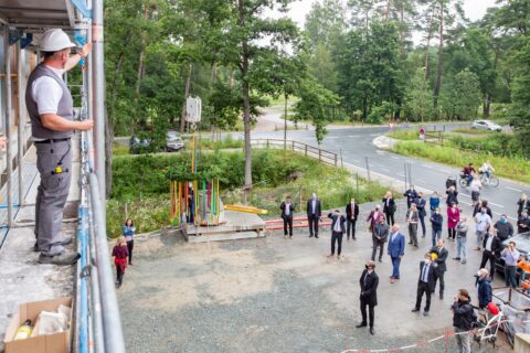 Das Foto zeigt die Baustelle des Gebäudes mit Würdenträgern und FAU-Beschäftigten im Hintergrund.