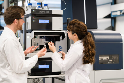 Im Labor der Lebensmittelchemie. Ein Student und eine Studentin geben Proben in ein Gerät. (Bild: Uwe Niklas/FAU)